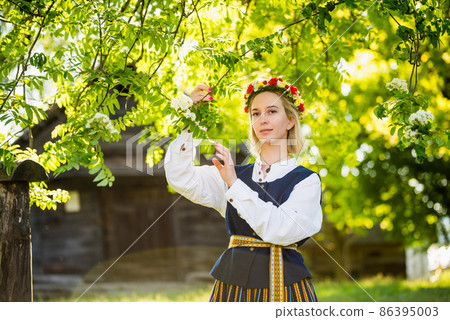Latvian woman in traditional clothing. Ligo folk. 86395003