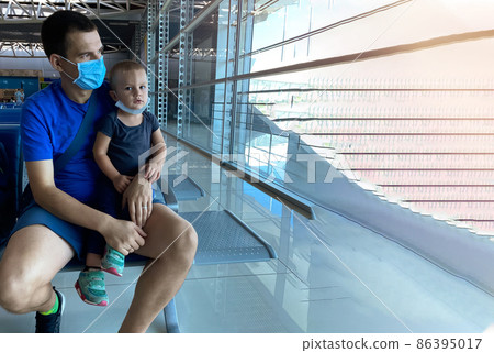 Father and son are waiting for a flight at the airport and having fun. Travel and tourism concept 86395017