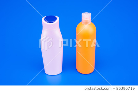 HDPE blue background. Refillable shampoo and conditioner bottles. Plastic cosmetic packaging bottles HDPE blue background. Refillable shampoo and conditioner bottles. Plastic cosmetic packaging bottles 86396719