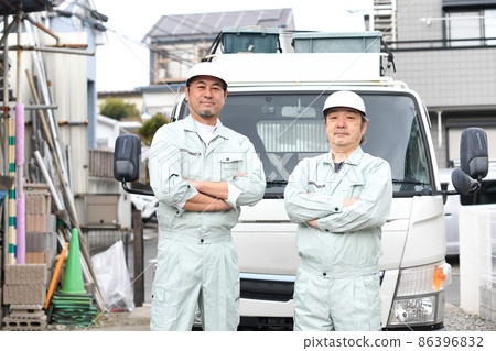 中高級男子身著工作服,雙臂交叉在卡車前 中高級男子身著工作服,雙臂交叉在卡車前 86396832