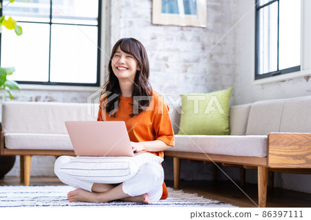 A young lady who plays a personal computer in the living room A young lady who plays a personal computer in the living room 86397111