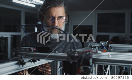 Mature designer watching work of 3D printer Mature designer watching work of 3D printer 86397326