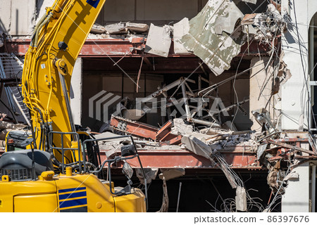 Demolition of RC structure: Heavy machinery demolishing steel frame 86397676