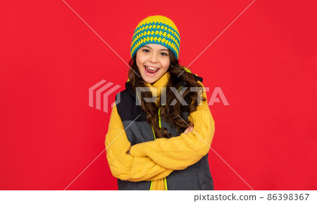 winter fashion. emotional happy kid with curly hair in hat. teen girl on red background. 86398367