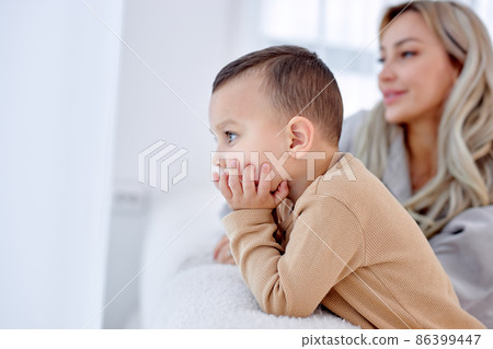 beautiful kid boy spend time with mom at home, looking at side, focus on child beautiful kid boy spend time with mom at home, looking at side, focus on child 86399447