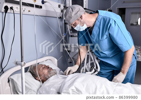 confident male doctor putting stethoscope to senior patient, checking the heartbeat. confident male doctor putting stethoscope to senior patient, checking the heartbeat. 86399980