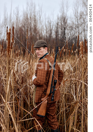 outdoor hunting on wild animals at autumn season. Man holding shotgun. on hunt outdoor hunting on wild animals at autumn season. Man holding shotgun. on hunt 86400414