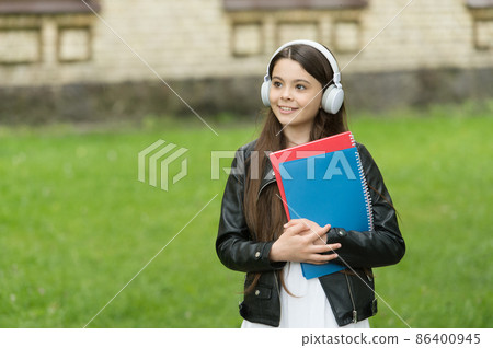 Schoolgirl listening audio books on way to school, audio lessons concept 86400945
