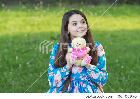 Girl kid hug soft toy teddy bear love symbol, kindness and charity concept 86400950