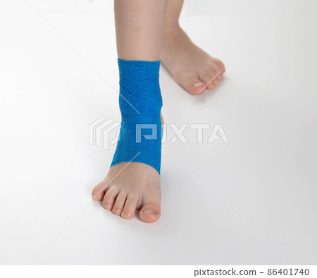 Blue elastic bandage on the ankle joint of a child. White background, close-up Blue elastic bandage on the ankle joint of a child. White background, close-up 86401740