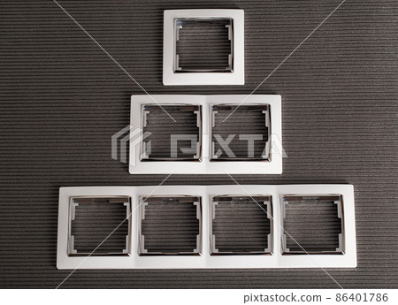 Modern frames for sockets on a gray background, close-up Modern frames for sockets on a gray background, close-up 86401786