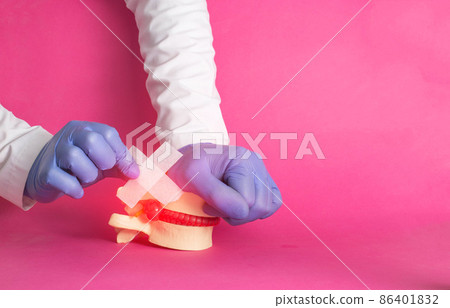 The doctor's hands are gluing a medical plaster on the released nucleus pulposus, intervertebral hernia, pink background. Spondylolisthesis and spondoarthrosis treatment concept, copy space for text The doctor's hands are gluing a medical plaster on the released nucleus pulposus, intervertebral hernia, pink background. Spondylolisthesis and spondoarthrosis treatment concept, copy space for text 86401832