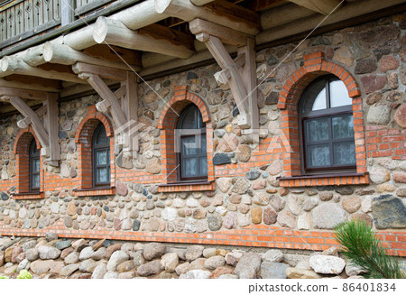 There are many semi-circular wooden windows in the stone building. Concept of architectural monument, fortress, beauty 86401834