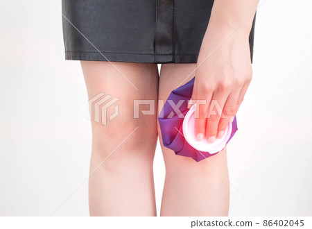 The girl applies a medical bag with cold to the injured knee for diseases of bursitis and sprains. Cold Knee Treatment, rheumatology The girl applies a medical bag with cold to the injured knee for diseases of bursitis and sprains. Cold Knee Treatment, rheumatology 86402045