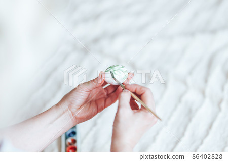 Hands painting modern style easter eggs with paint selected focus Hands painting modern style easter eggs with paint selected focus 86402828