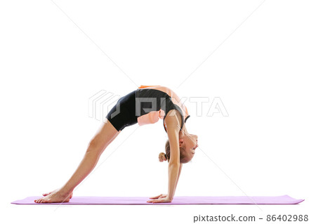 One flexible young girl, rhythmic gymnastics artist practicing isolated on white studio background. Grace in motion, action. Doing exercises in flexibility. One flexible young girl, rhythmic gymnastics artist practicing isolated on white studio background. Grace in motion, action. Doing exercises in flexibility. 86402988