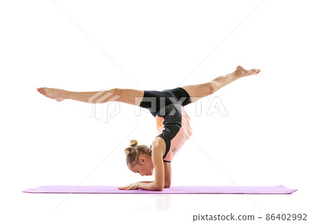 Little flexible girl, rhythmic gymnastics artist isolated on white studio background. Grace in motion, action. Doing exercises in flexibility. Little flexible girl, rhythmic gymnastics artist isolated on white studio background. Grace in motion, action. Doing exercises in flexibility. 86402992