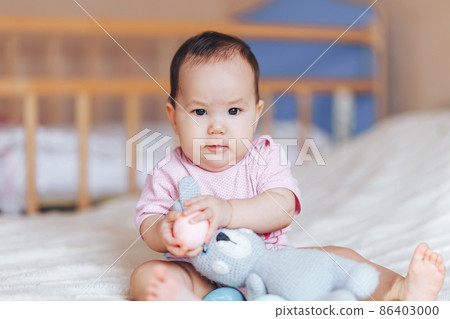 Cute little baby girl, playing with colorful easter eggs 86403000