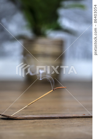 Concept of slow-living and mindfulness. Aromatic saldanwood frankincense smolding stick. Burning candle. Aromatherapy practise. Finding peace and rest. Spiritual ritual at home 86403054