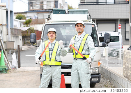 Men in work clothes holding a guide stick to guide traffic 86403263