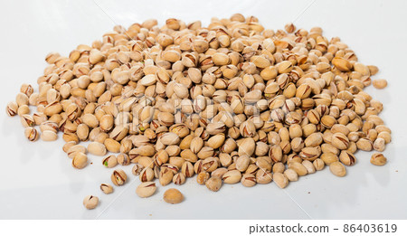 Pile of unshelled pistachios on white Pile of unshelled pistachios on white 86403619