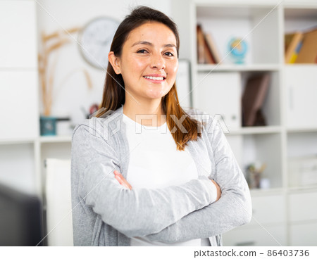 Positive businesswoman posing in office 86403736