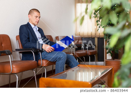 Man with briefcase waiting for job interview at office Man with briefcase waiting for job interview at office 86403944