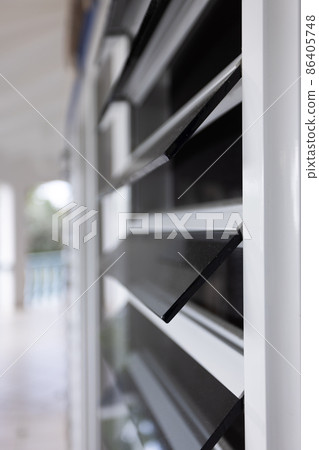 Blinds from tinted glass. Windows and doors in the tropics. Selective focus. 86405748