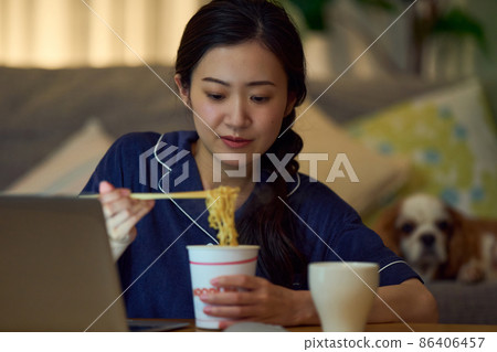 Female eating cup ramen for a midnight snack 86406457