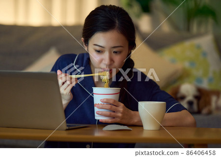 女性吃杯拉麵作為宵夜 86406458