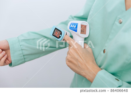 Temperature measurement gun in doctor hands. Close-up shot of doctor wearing protective surgical mask ready to use infrared isometric thermometer gun to check body temperature for virus symptoms. Temperature measurement gun in doctor hands. Close-up shot of doctor wearing protective surgical mask ready to use infrared isometric thermometer gun to check body temperature for virus symptoms. 86406648