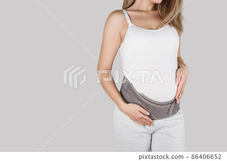 Pregnant woman belly in prenatal pregnancy maternity belt. Orthopedic abdominal support waist, back, abdomen band. Belly brace or band for pregnancy. Horizontal web banner. Torso of pregnant model. 86406652