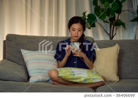 A woman looking at a smartphone at midnight A woman looking at a smartphone at midnight 86406699