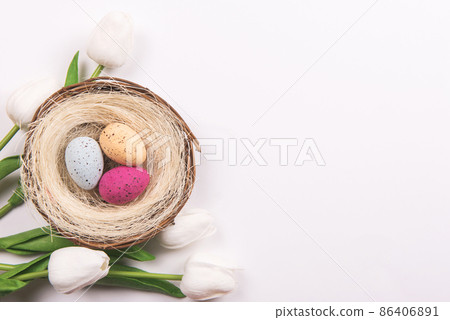 Colorful decorations with Easter egg nest and tulips on white background. copy space, top view 86406891