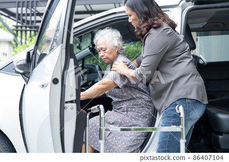 Help and support asian senior or elderly old lady woman patient walk with walker prepare get to her car, healthy strong medical concept. 86407104