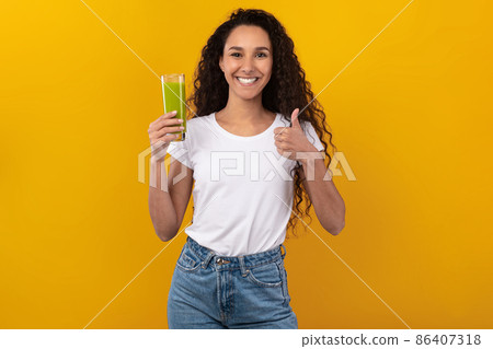 Portrait of Smiling Young Lady Drinking Smoothie Showing Like Portrait of Smiling Young Lady Drinking Smoothie Showing Like 86407318