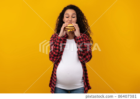 Funny Pregnant Latin Lady Holding Burger Biting Sandwich At Studio Funny Pregnant Latin Lady Holding Burger Biting Sandwich At Studio 86407381