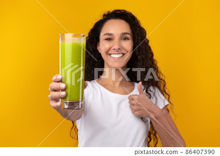 Portrait of Smiling Young Lady Drinking Smoothie Showing Like 86407390