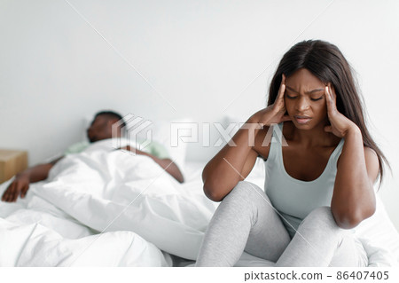 Depressed despaired sad young african american female suffers from snoring sleeping guy, lady covers ears 86407405