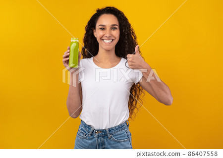 Portrait of Smiling Young Lady Drinking Smoothie Showing Like 86407558