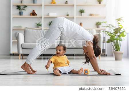 Motherhood And Fitness. Happy Black Woman Exercising With Little Son At Home 86407631