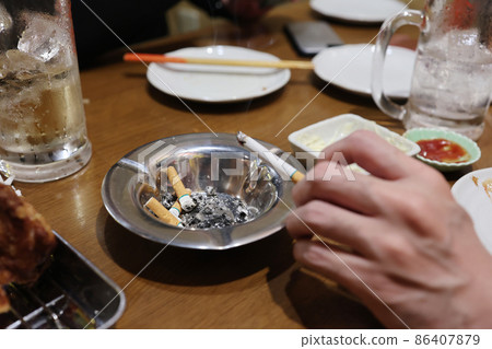 An ashtray with butts on the table An ashtray with butts on the table 86407879
