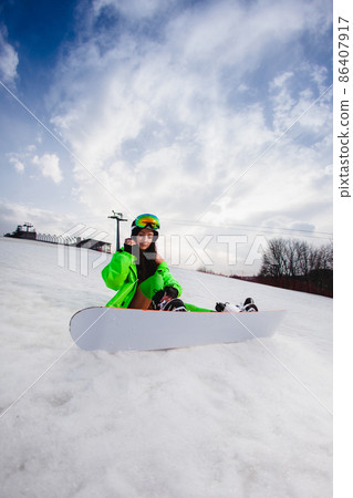 Young beautiful woman posing with a snowboard on a ski slope 86407917
