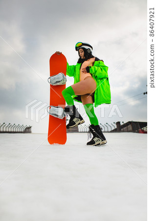Young beautiful woman posing with a snowboard on a ski slope 86407921