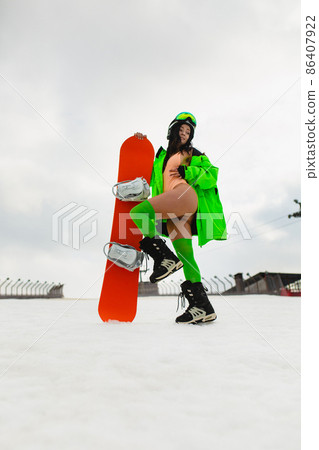 Young beautiful woman posing with a snowboard on a ski slope 86407922