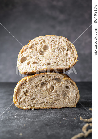 Sourdough artisan homemade bread sliced in halfs on dark background. 86408176