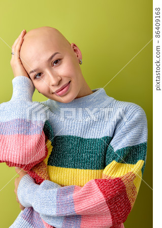 Portrait of smiling caucasian bald female in bright colorful shirt touching head 86409168