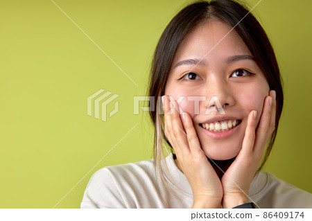 Asian women hand touch cheek looking on something with shocked and surprised face 86409174