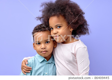 portrait of two smiling curly siblings brother and sister hugging each other, isolated portrait of two smiling curly siblings brother and sister hugging each other, isolated 86409445