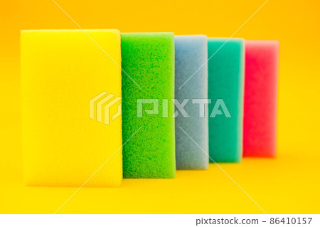 Multi-colored foam rubber sponge for cleaning and washing dishes on a yellow background 86410157